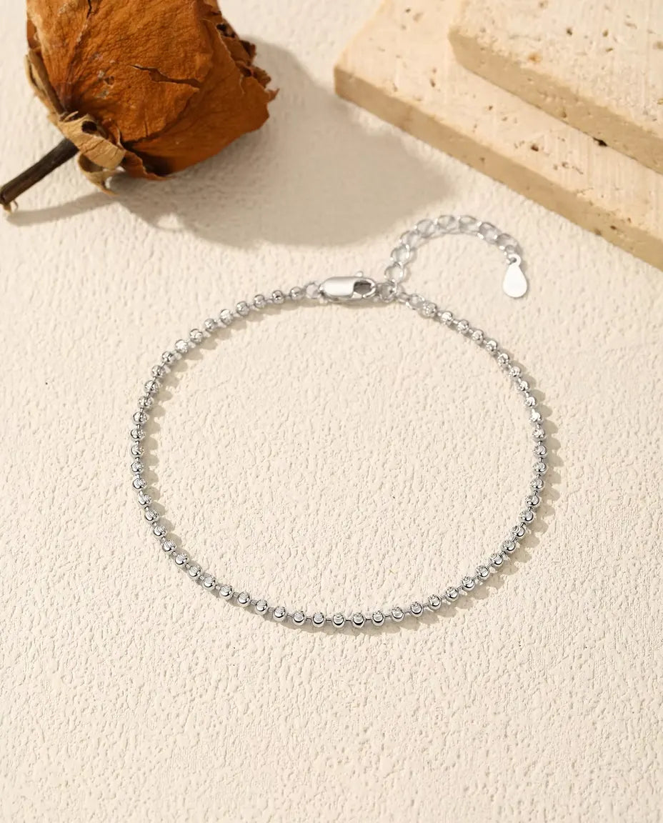 Armband met Gefacetteerde Kralen in 925 Sterling Zilver - plat op een licht gestructureerd oppervlak met sluiting en verlengketting