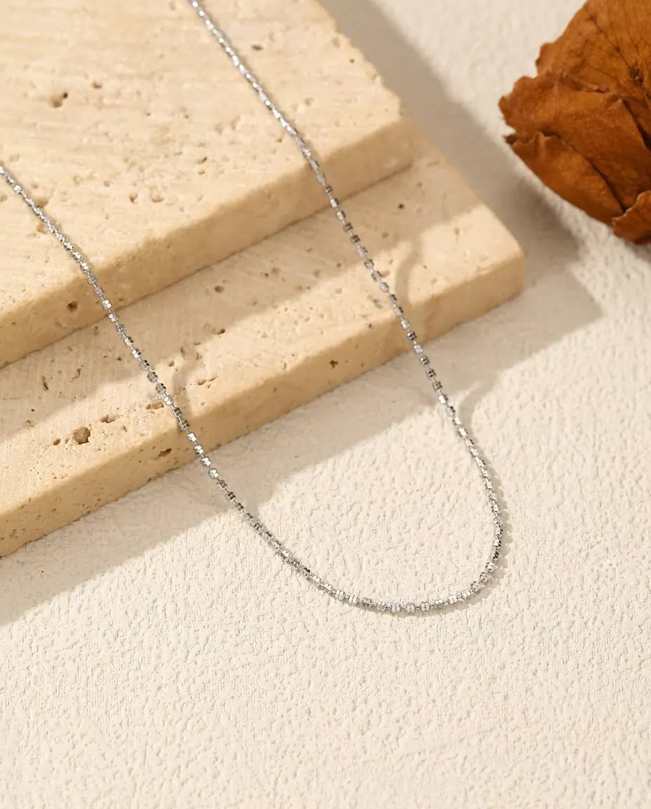 Diamantgeslepen Ketting in 925 Sterling Zilver - op een licht oppervlak naast een travertijnplaat