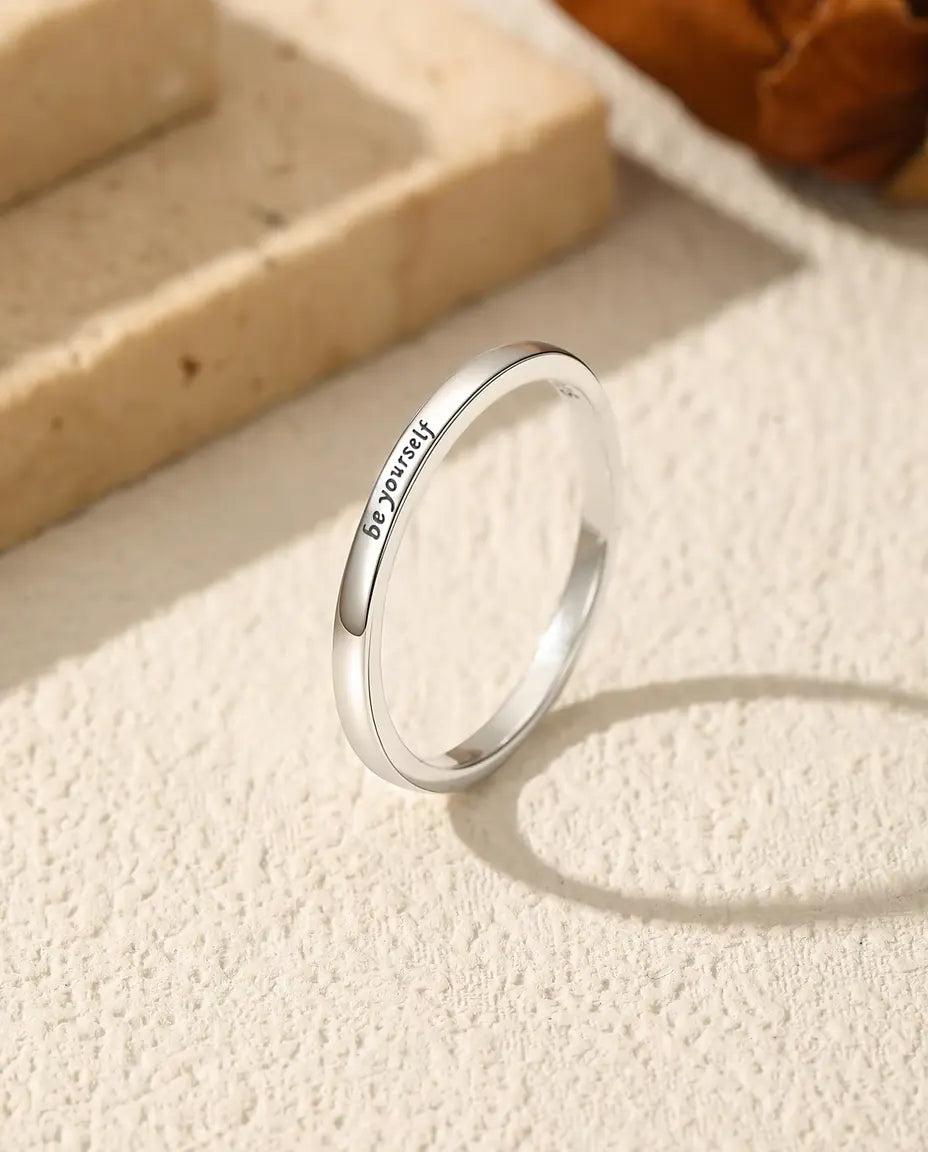 Gegraveerde Ring “be yourself” in 925 Sterling Zilver - rechtop op een licht gestructureerd oppervlak