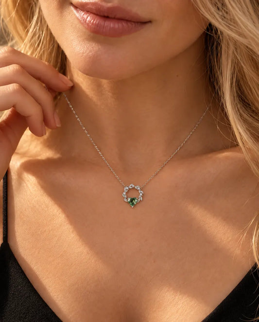 Mosagaat Hartje Ketting in 925 Sterling Zilver - gedragen door een model met haar hand bij haar hals