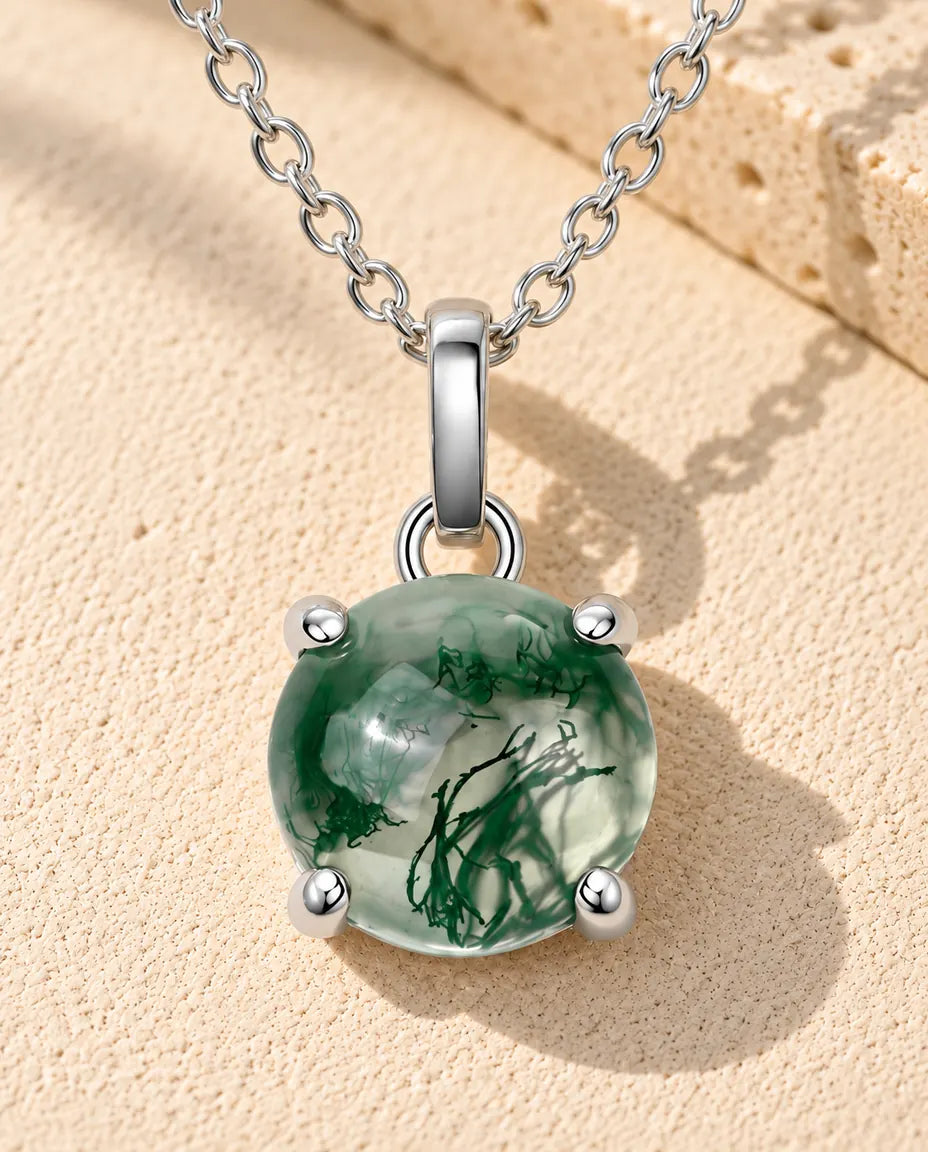 Ronde Mosagaat Ketting in 925 Sterling Zilver - liggend op een licht gestructureerd oppervlak naast een blok travertijn