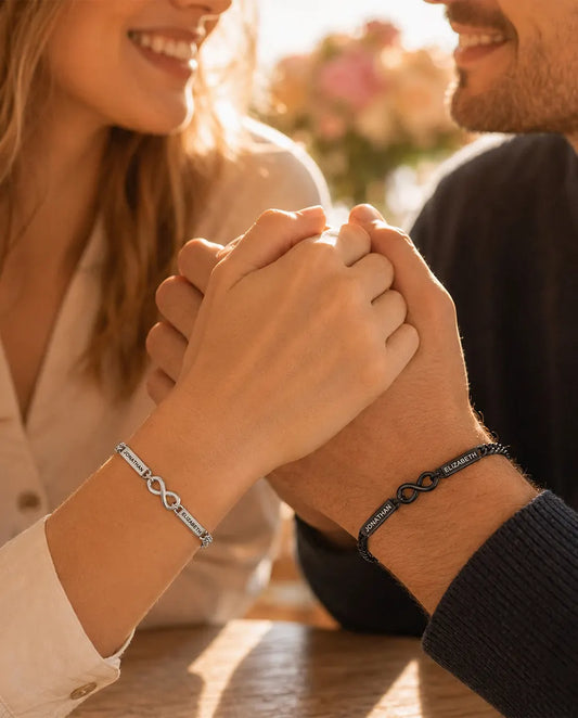 Gepersonaliseerde Koppel Armbanden met 2 Gegraveerde Namen - Bijpassende Oneindigheidsarmbanden Zilverkleurig en Zwart - gedragen door een stel, hand in hand