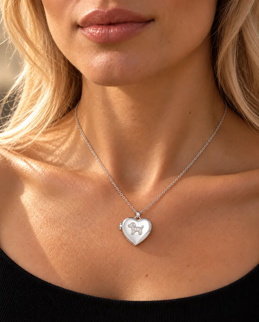 Vrouw in een zwarte gebreide top draagt de ketting met het zilverkleurige hartmedaillon met puppy