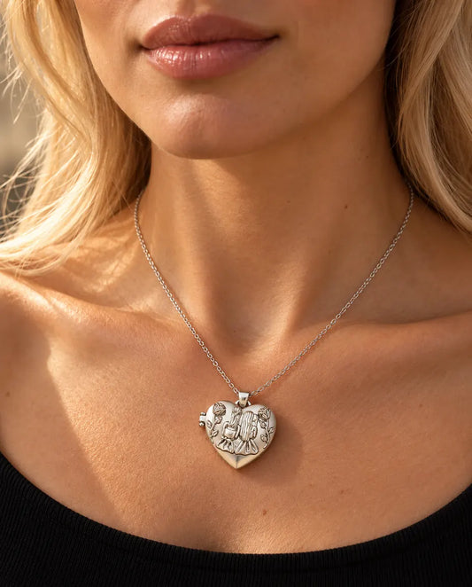 Vrouw in een zwarte gebreide top draagt de zilverkleurige ketting met hartmedaillon met twee zusjes