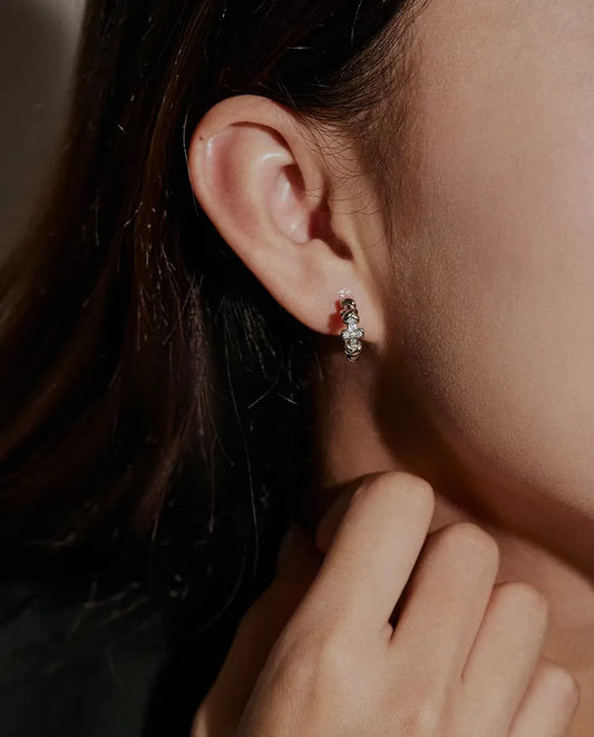Moissanite Creolen met Kruisje in 925 Sterling Zilver - gedragen in het oor van een model, hand bij het gezicht