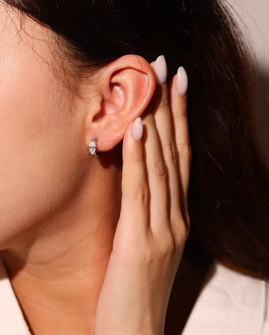 Moissanite Creolen in 925 Sterling Zilver - gedragen in het oor van een model, hand bij het gezicht