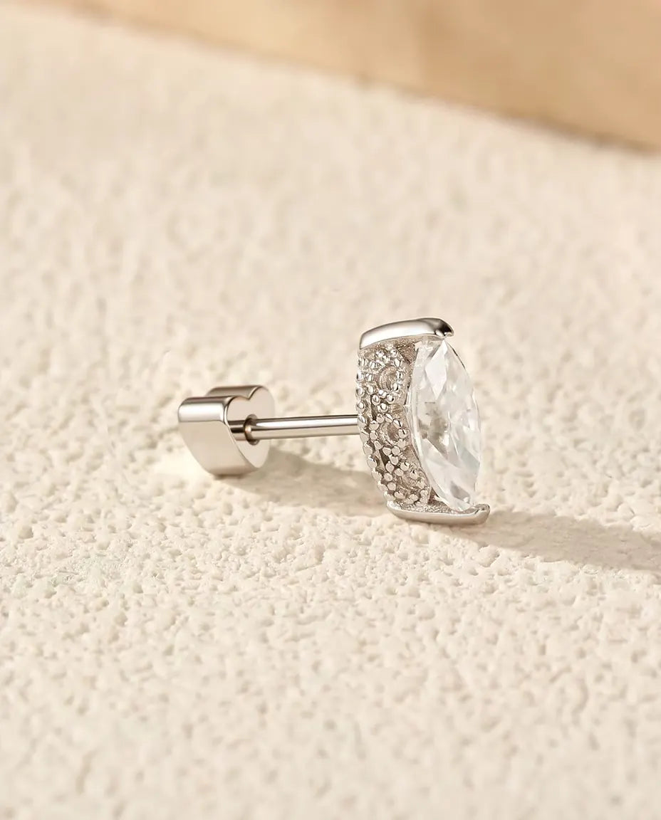 Moissanite Oorknopjes Marquise in 925 Sterling Zilver - op een licht gestructureerd oppervlak naast een travertijnplaat