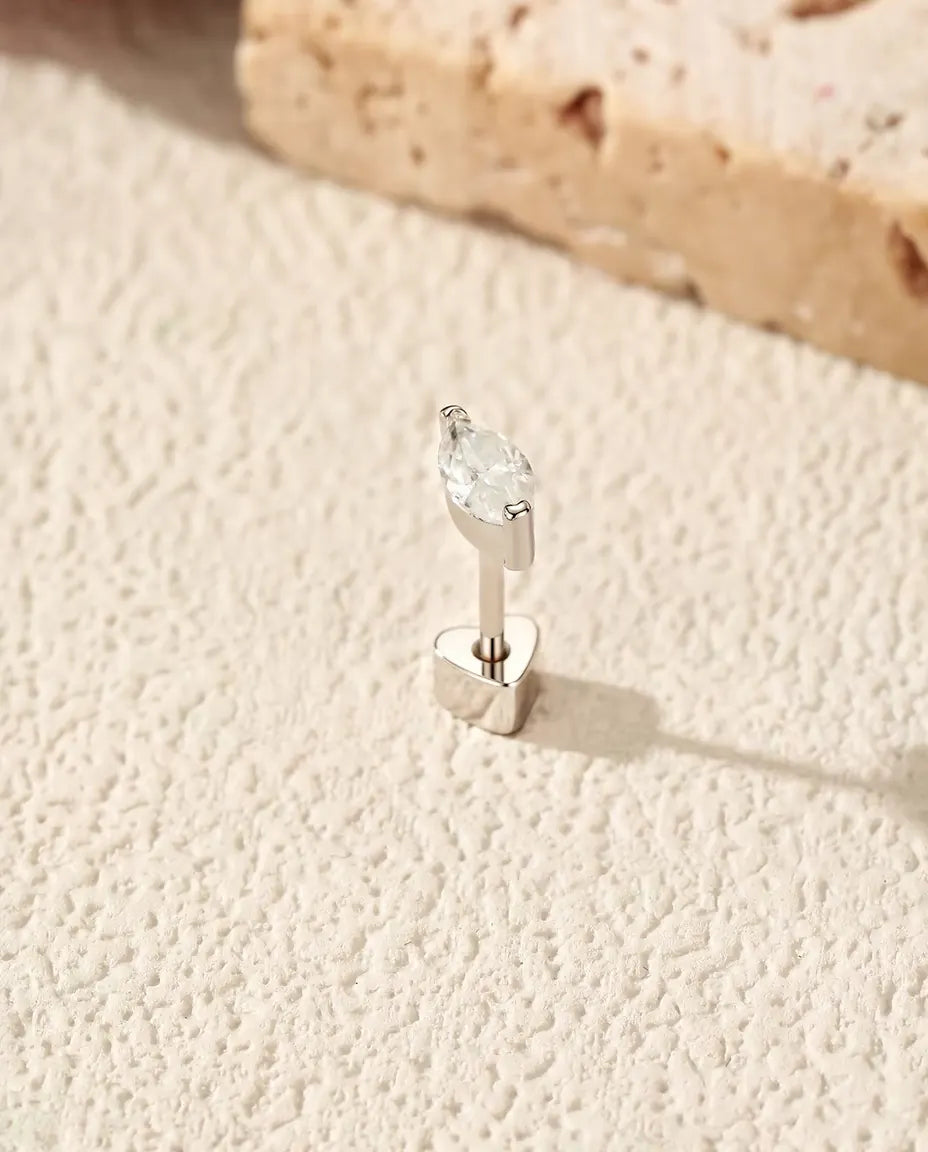 Moissanite Oorknopjes Marquise in Halve Kastzetting - rechtop op het hartvormige achterkantje, op een licht gestructureerd oppervlak