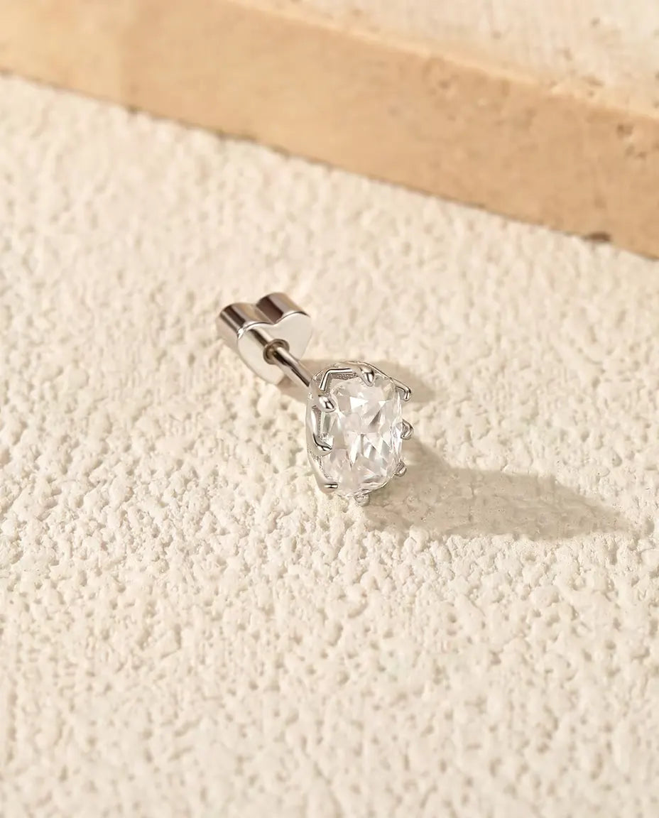 Moissanite Oorknopjes Radiant Geslepen in 925 Sterling Zilver - op een licht gestructureerd oppervlak naast een travertijnplaat