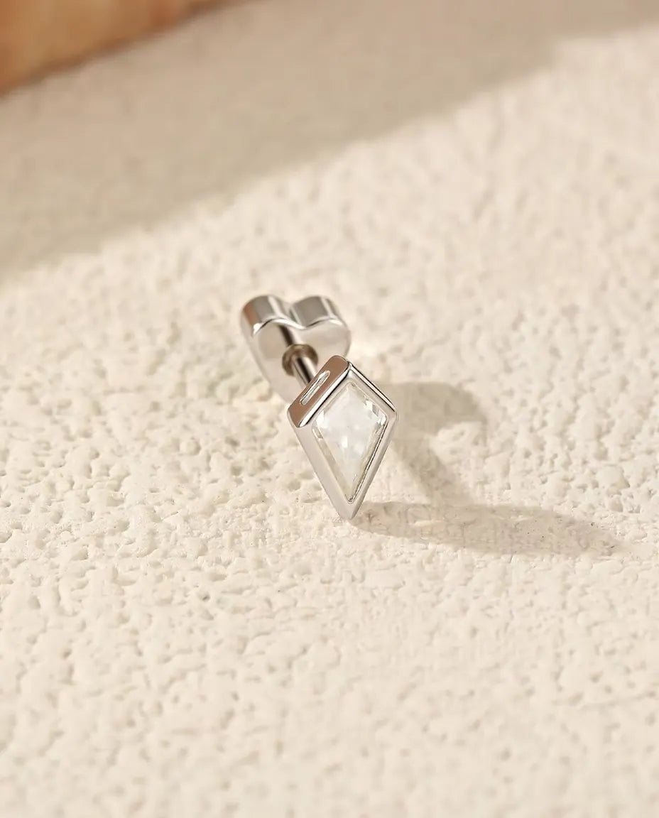 Moissanite Oorknopjes Vliegervorm in 925 Sterling Zilver - op zijn kant op een licht gestructureerd oppervlak, hartvormig achterkantje op de stift