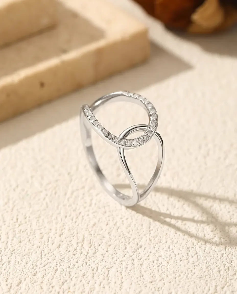 Ring met Verstrengelde Cirkels in 925 Sterling Zilver - rechtop op een licht gestructureerd oppervlak