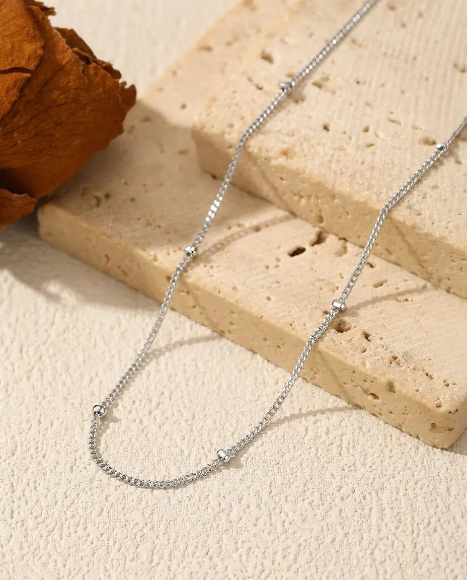 Satellietketting in 925 Sterling Zilver - op een licht oppervlak naast een travertijnplaat