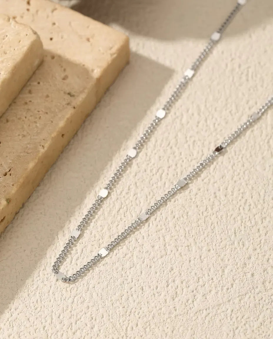 Stationketting in 925 Sterling Zilver - op een licht oppervlak naast een travertijnplaat