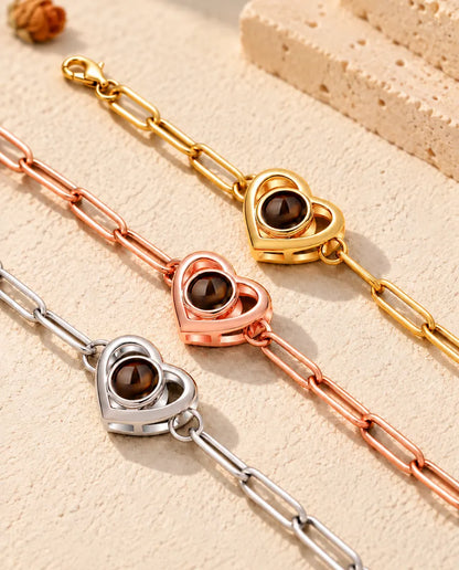 Close-up van drie armbanden met dubbel hart in goudkleurig, roségoudkleurig en zilverkleurig