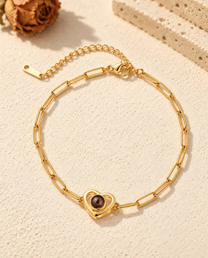 Bovenaanzicht van de goudkleurige armband met dubbel hart aan een paperclipketting en het verlengkettinkje