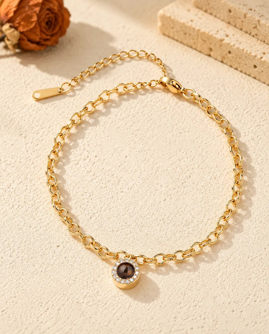 Bovenaanzicht van de goudkleurige armband met rond zirkonia-bedeltje en het verlengkettinkje