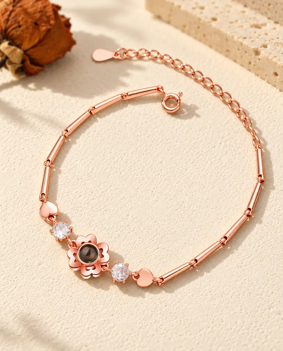Roségoudkleurige armband met klavertjesbloem, zirkonia en kleine hartjesschakels