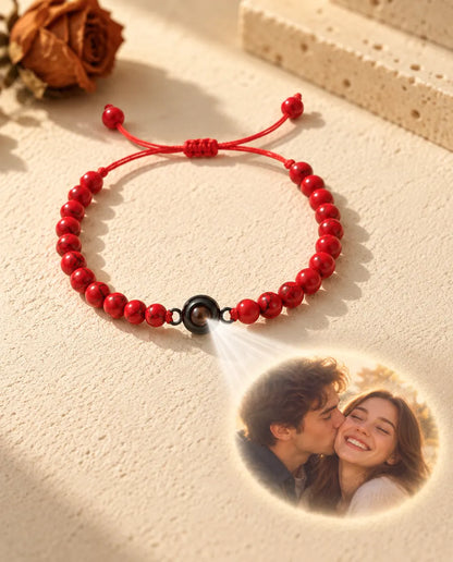 Licht door het bruine steentje van de rode kralenarmband projecteert een foto van een lachend stel