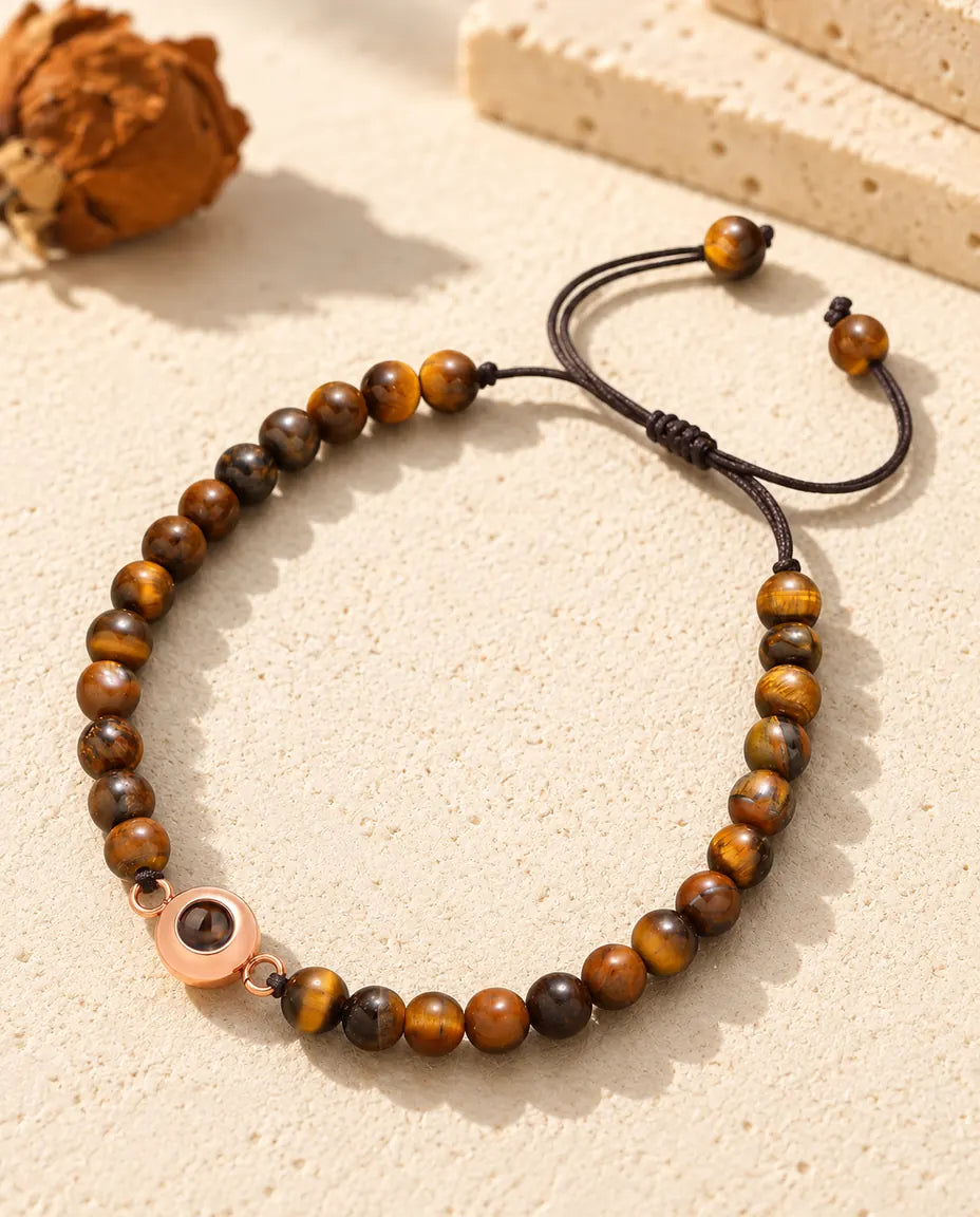 Kralenarmband van tijgeroog met een roségoudkleurige ringbedel waarin je foto verborgen zit