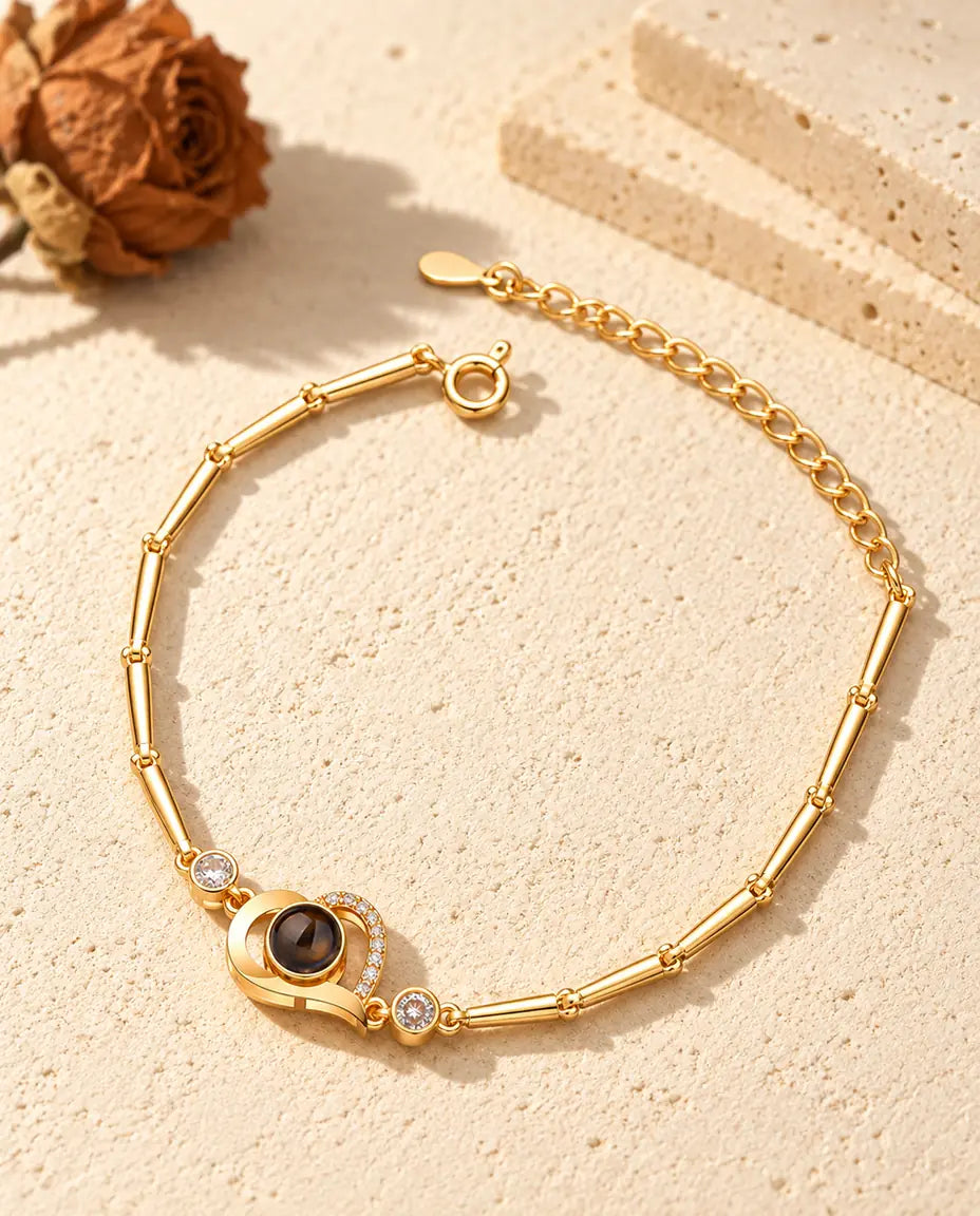Goudkleurige armband met open hartje, rijtje zirkonia, zijsteentjes en veerringsluiting