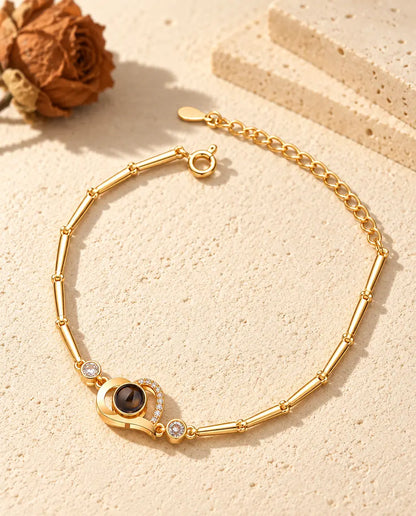 Goudkleurige armband met open hartje, rijtje zirkonia, zijsteentjes en veerringsluiting