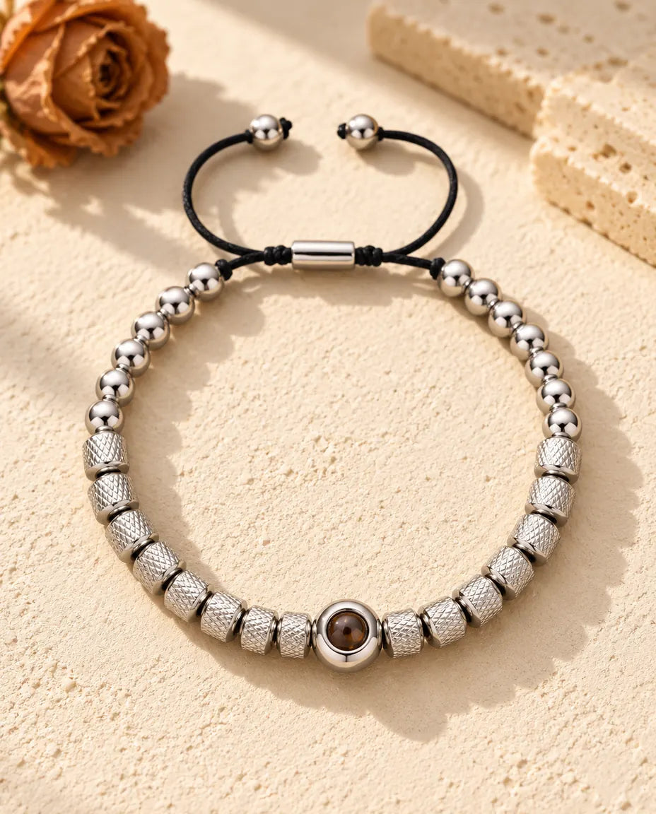 Zilverkleurige armband met gekartelde kralen en een ronde projectiekraal voorin