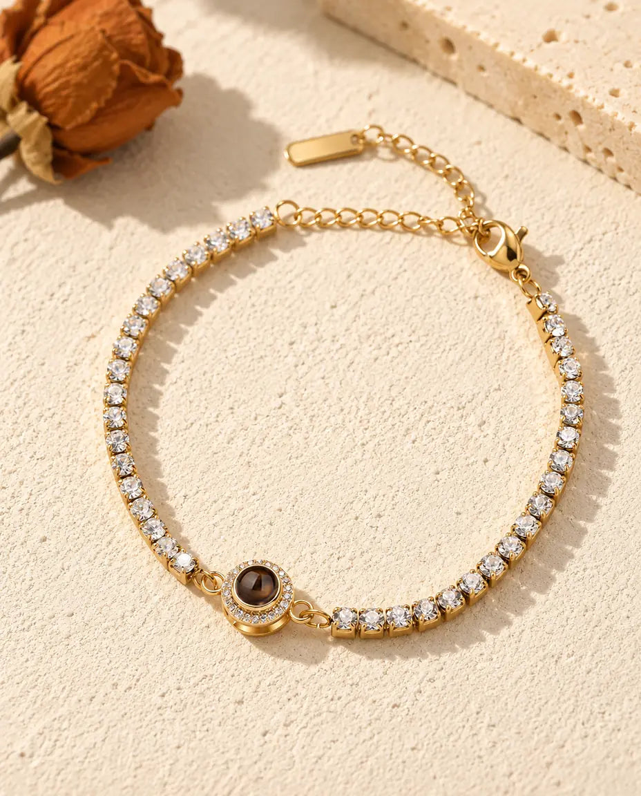 Bovenaanzicht van de goudkleurige tennisarmband met halo-bedel en de verlengketting erbij