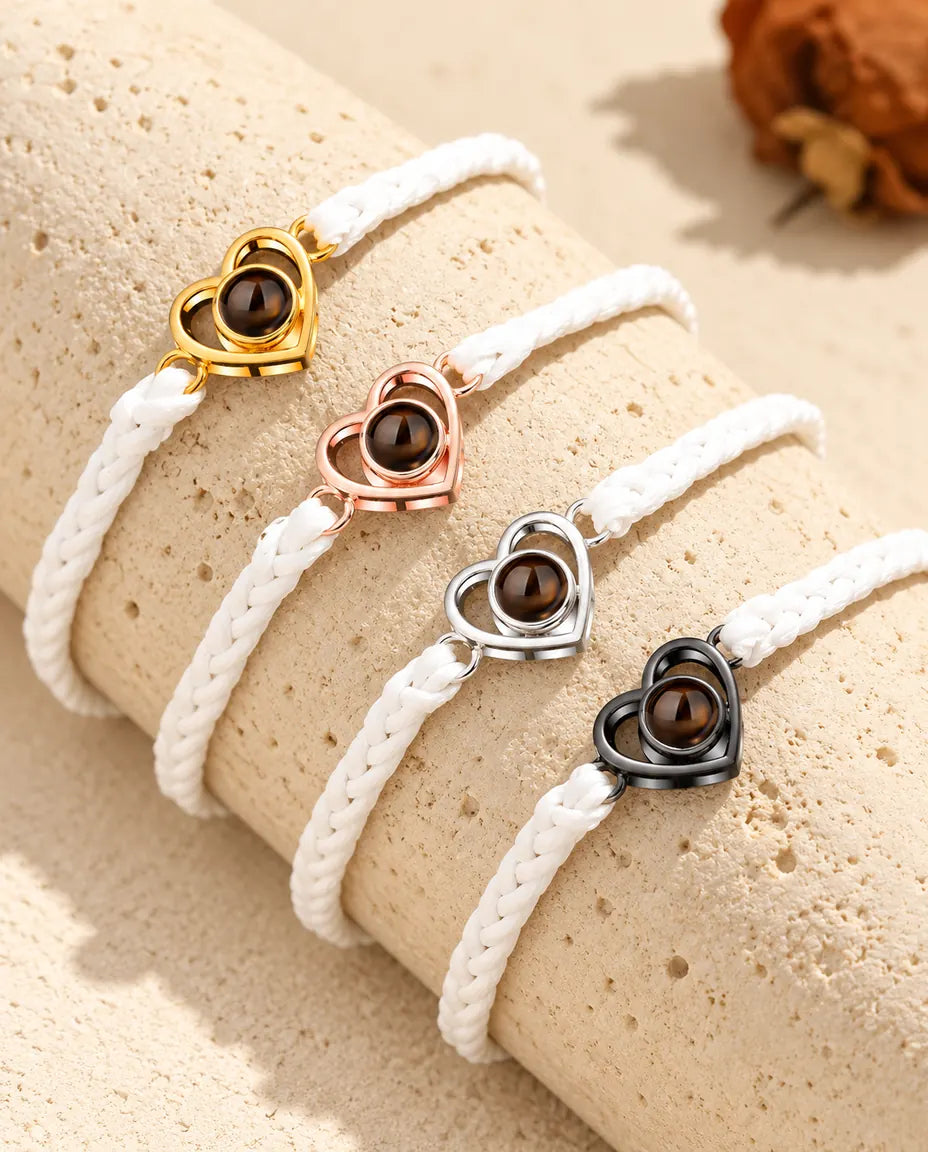 Witte gevlochten armbanden met open hartje, op een rij in elke bedelkleur