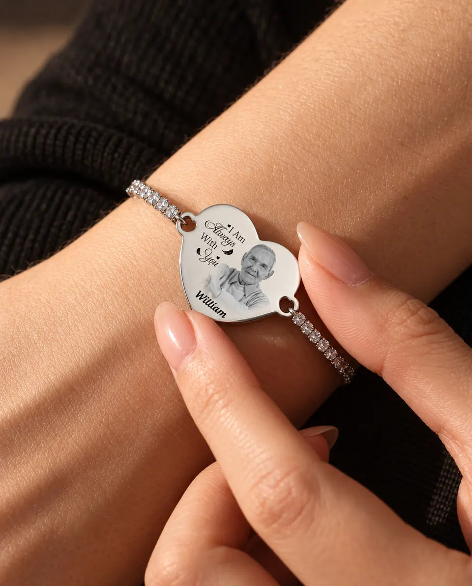Vingertoppen houden het gegraveerde fotohart van de zilverkleurige tennisarmband vast