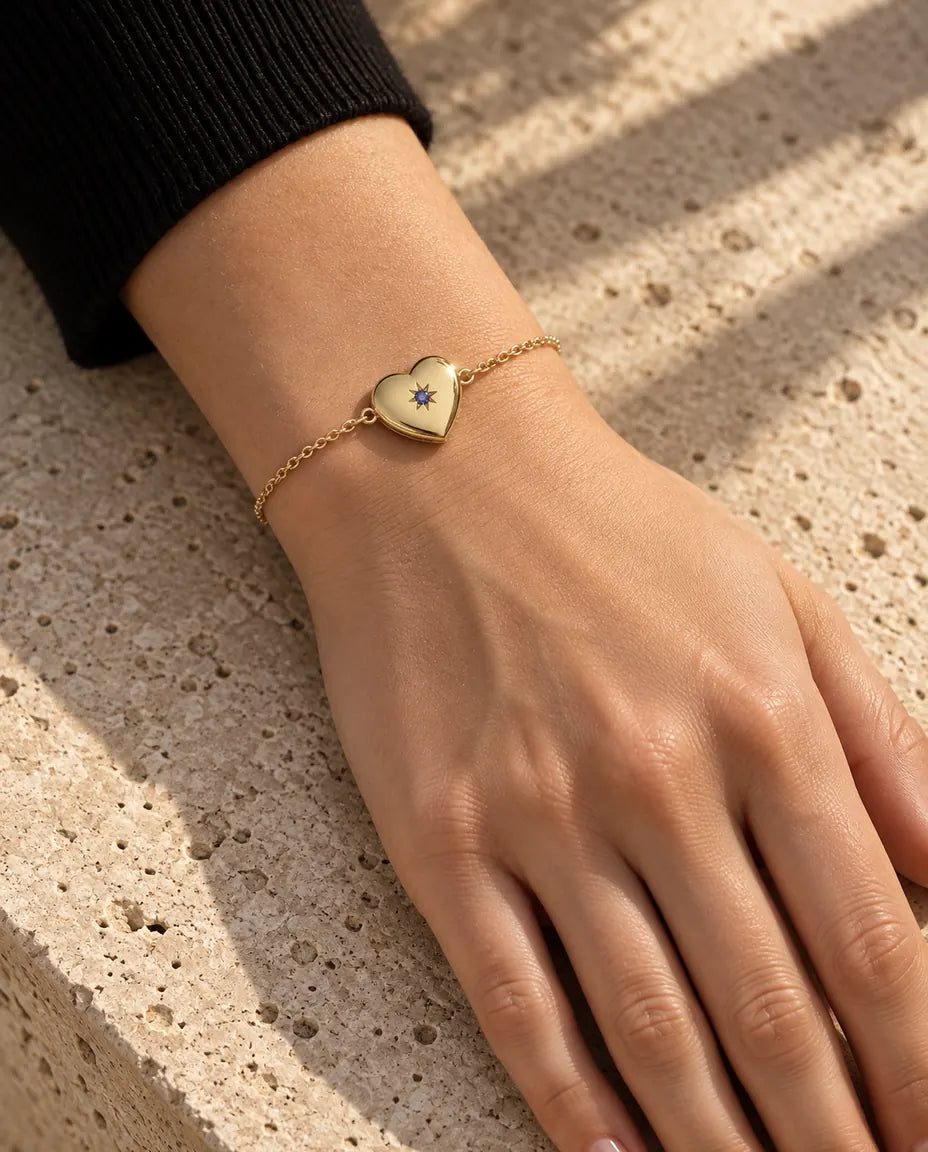 Close-up van de armband met hartmedaillon om de pols