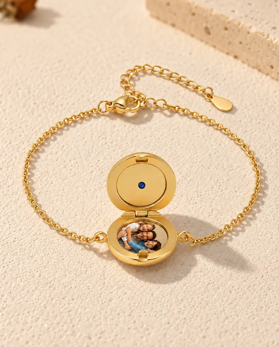 Armband met rond medaillon open, één foto in de onderkant en een gladde goudkleurige deksel