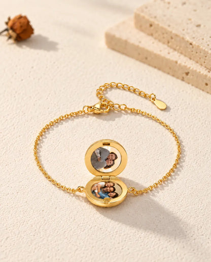 Armband met open rond medaillon en twee foto's, van laag gezien