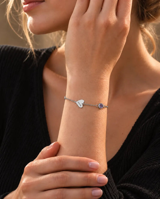 Vrouw draagt de armband met namen en geboortestenen, hier met één gegraveerd hartje