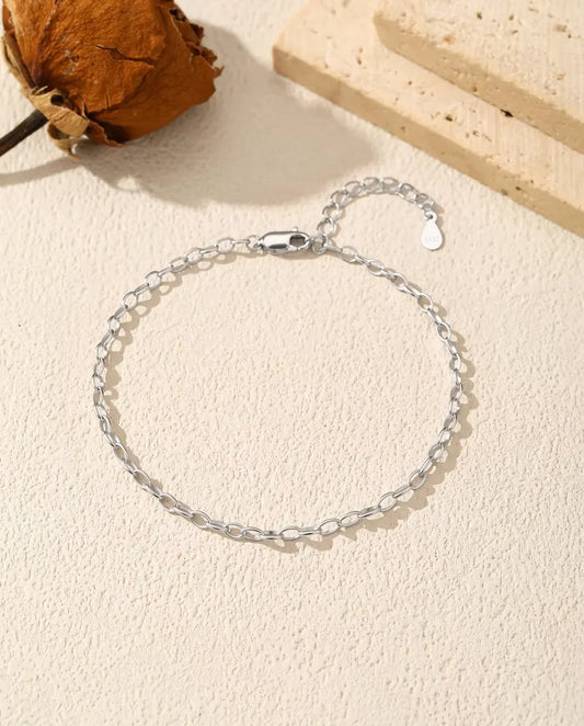 Armband met Ovale Ankerschakels in 925 Sterling Zilver - plat op een licht gestructureerd oppervlak met sluiting en verlengketting