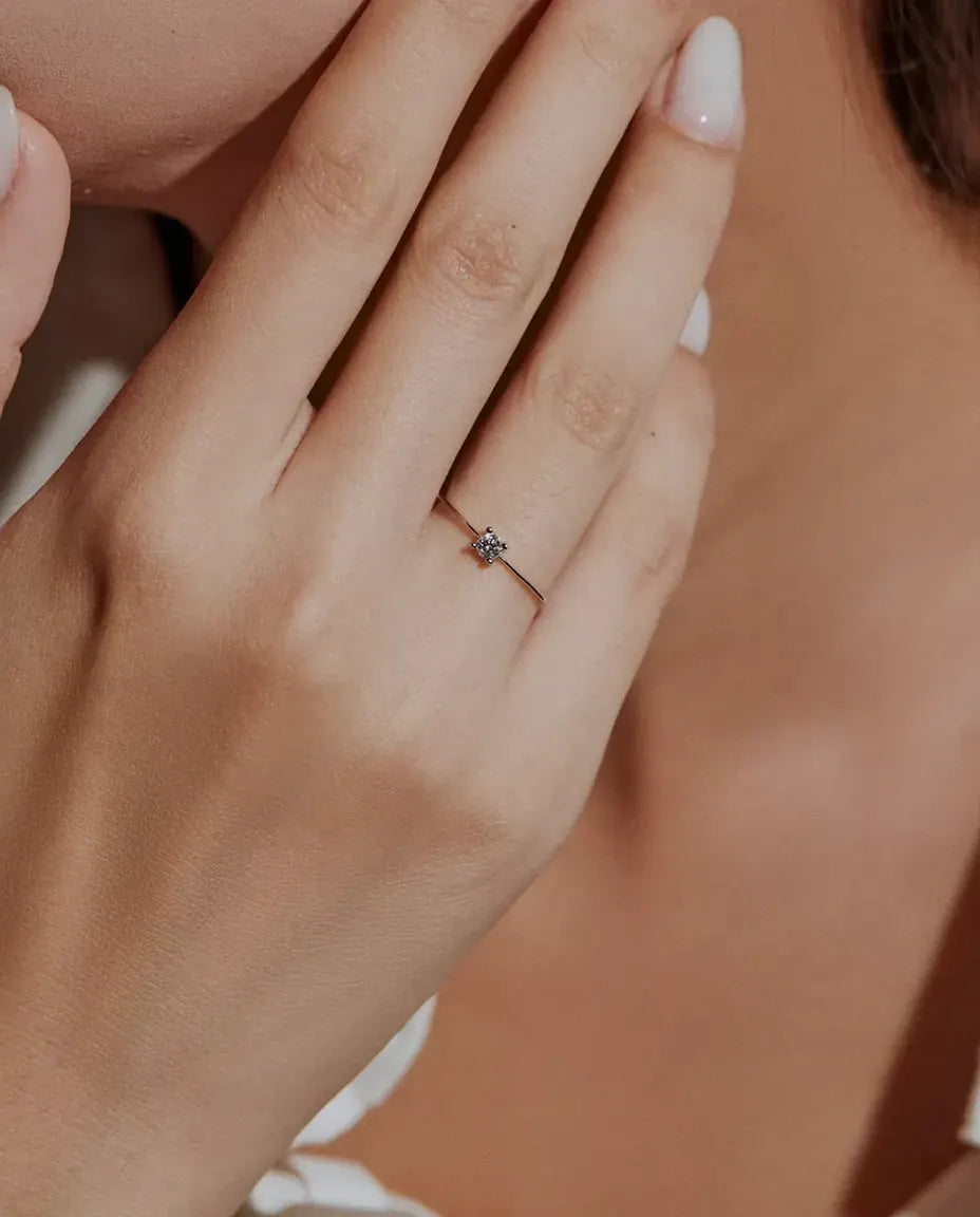 Fijne Moissanite Ring in 925 Sterling Zilver - gedragen door een model met haar handen bij haar gezicht