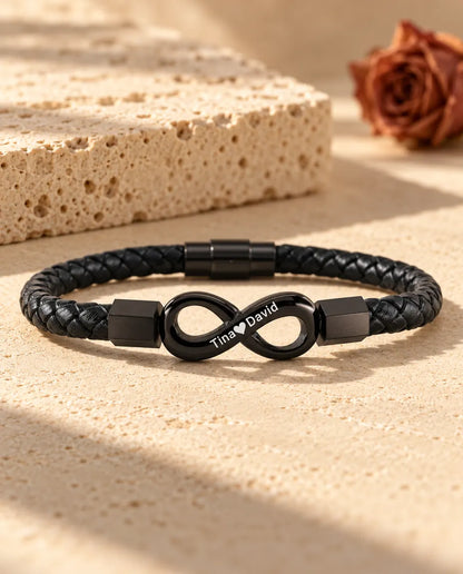 Gepersonaliseerde herenarmband met zwart oneindigheidsteken op gevlochten kunstleer, gegraveerd met twee namen en een hartje