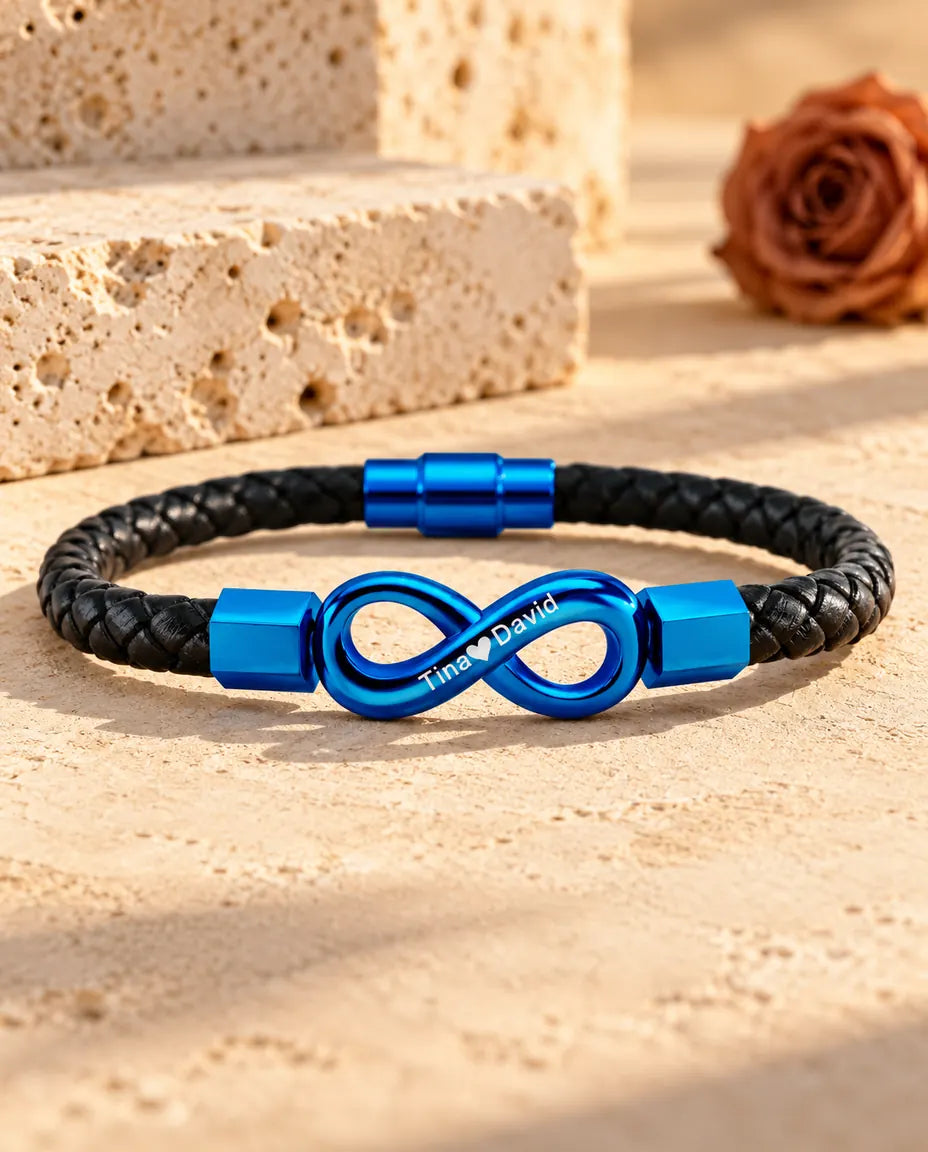 Blauwe gegraveerde armband met oneindigheidsteken en blauwe magneetsluiting op een zwart koord van gevlochten kunstleer