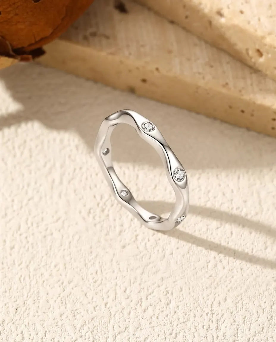 Golvende Moissanite Ring in 925 Sterling Zilver - rechtop op een licht gestructureerd oppervlak
