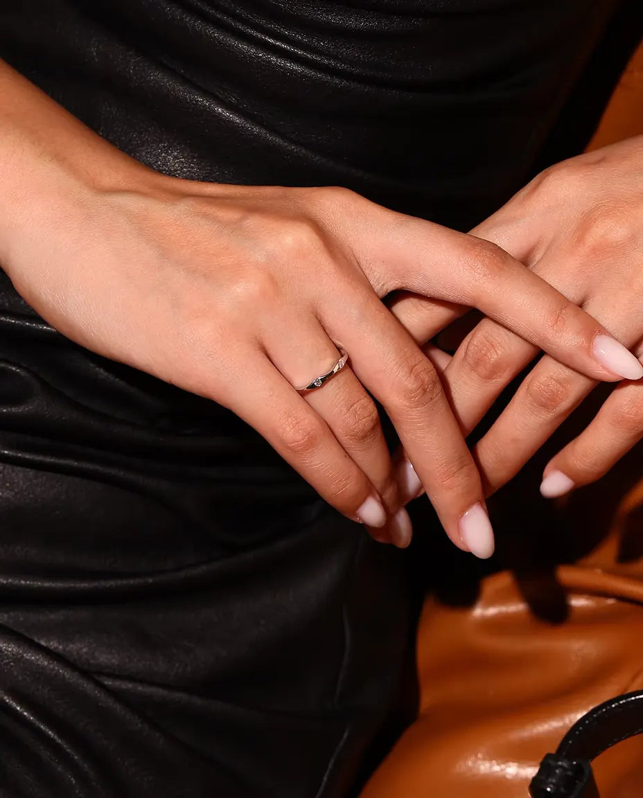 Golvende Moissanite Ring in 925 Sterling Zilver - gedragen door een model met gekruiste handen