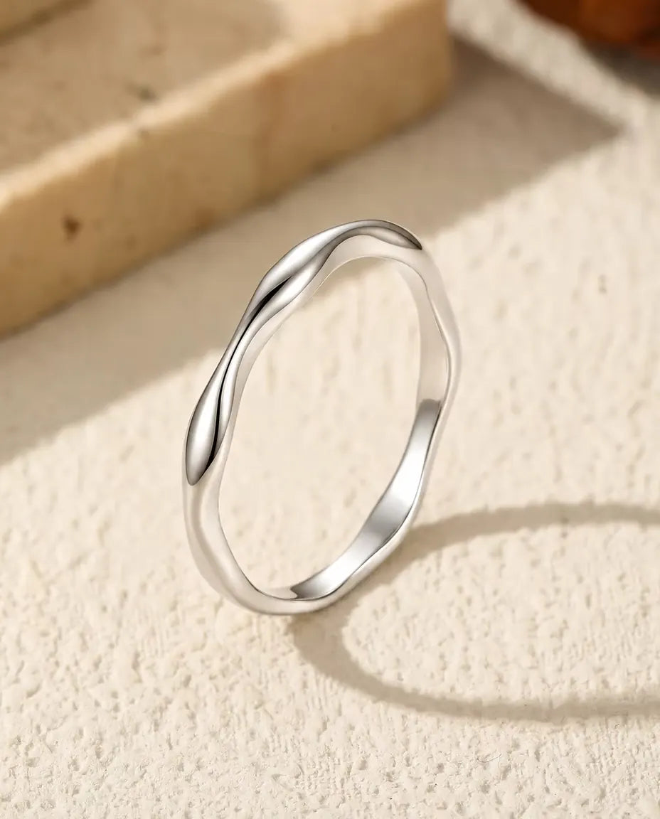 Golvende Ring in 925 Sterling Zilver - rechtop op een licht gestructureerd oppervlak