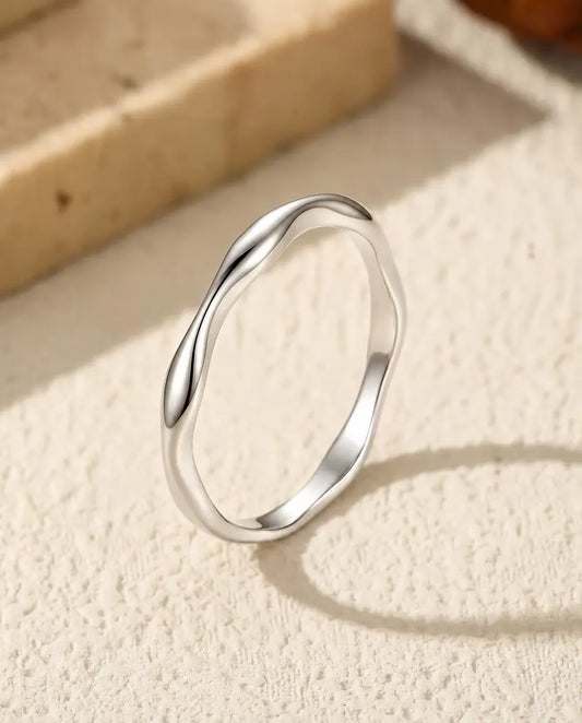 Golvende Ring in 925 Sterling Zilver - rechtop op een licht gestructureerd oppervlak
