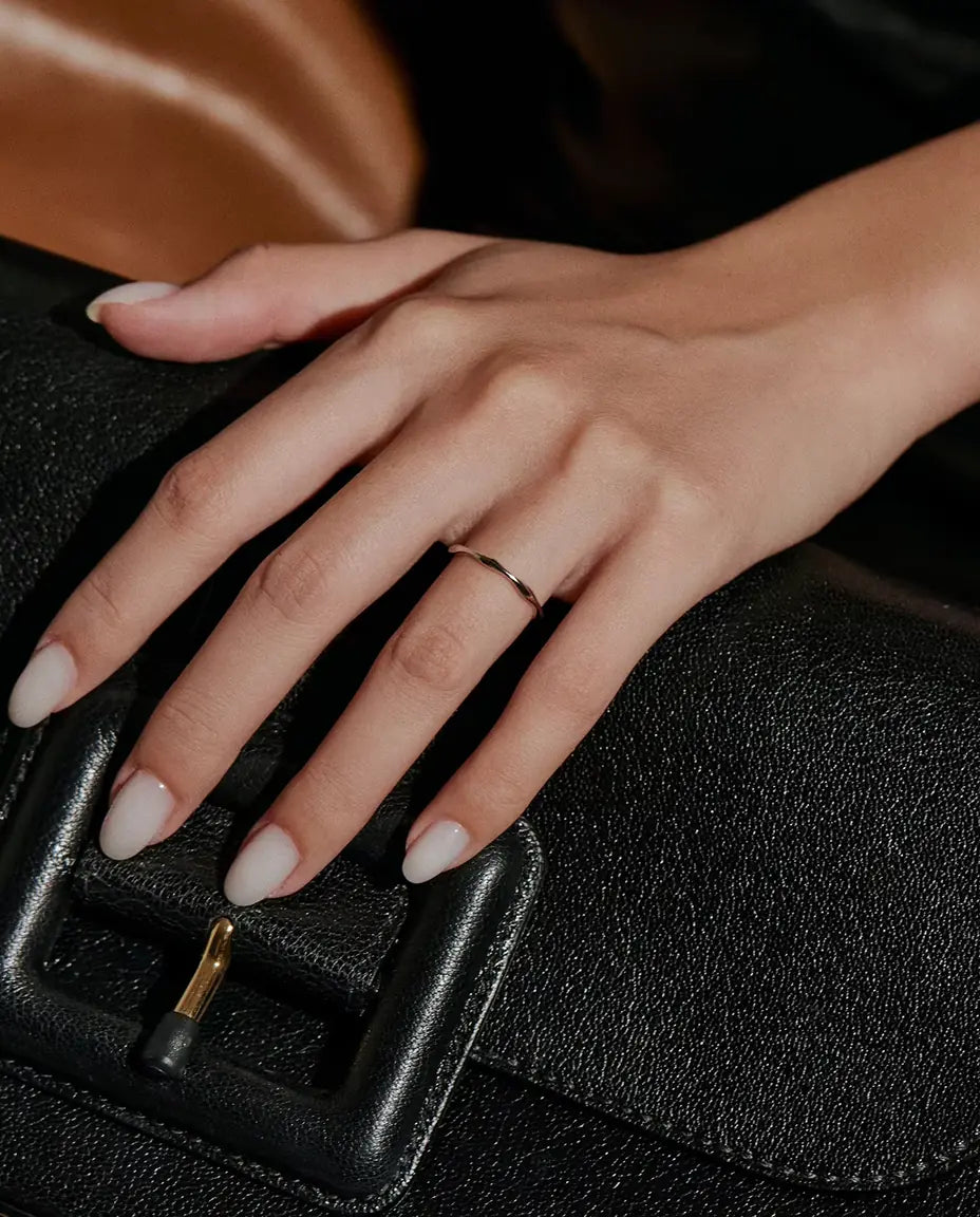 Golvende Ring in 925 Sterling Zilver - gedragen aan een hand op een zwarte tas