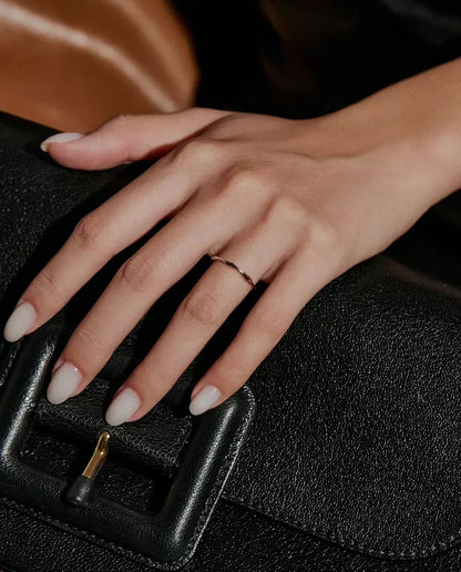 Golvende Ring in 925 Sterling Zilver - gedragen aan een hand op een zwarte tas