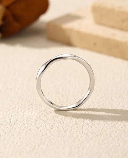 Golvende Ring in 925 Sterling Zilver - van voren, rechtop op een licht gestructureerd oppervlak