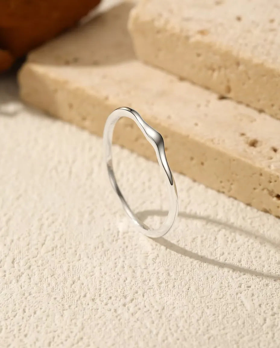 Golvende Stapelring in 925 Sterling Zilver - rechtop op een licht gestructureerd oppervlak