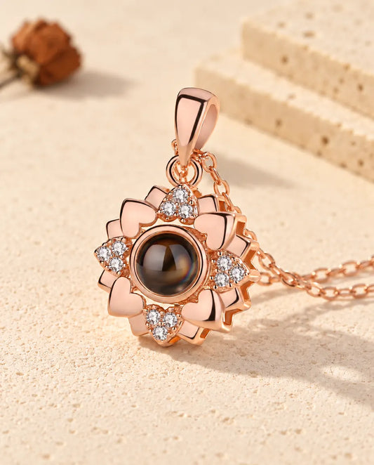 Gepersonaliseerde roségoudkleurige ketting met foto erin: bloem van hartjes met zirkonia op crèmekleurig gips