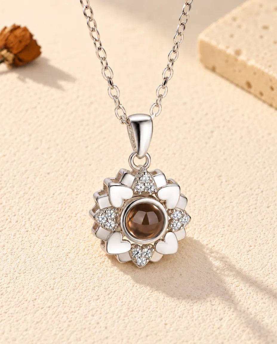 Vooraanzicht van de zilverkleurige ketting met bloem van hartjes en foto erin