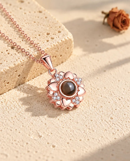 Roségoudkleurige ketting met bloem van hartjes op gips in warm zonlicht