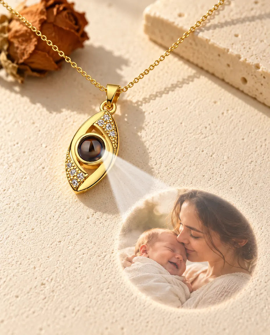 Goudkleurige ketting met het boze oog projecteert een foto van moeder en baby op gips