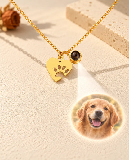Licht schijnt door het kleine bruine steentje van de goudkleurige ketting en projecteert een foto van een golden retriever